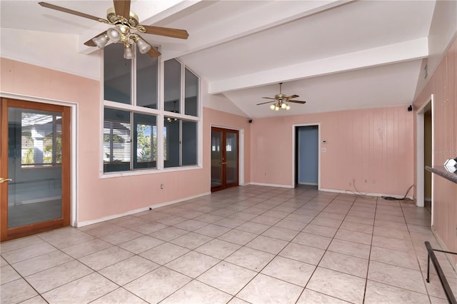 unfurnished living room with ceiling fan, wooden walls, lofted ceiling with beams, and light tile patterned floors