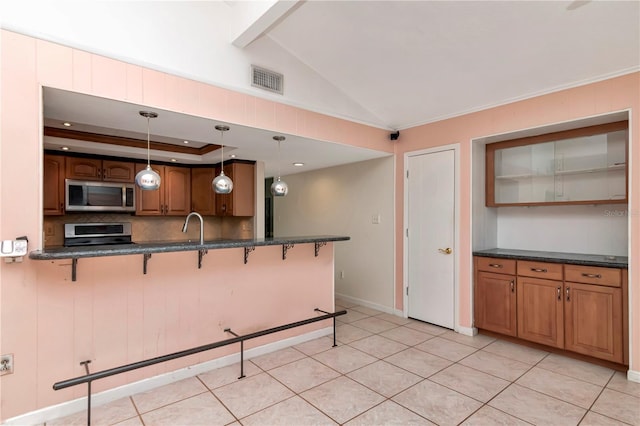 kitchen featuring decorative light fixtures, a kitchen breakfast bar, vaulted ceiling, and stove