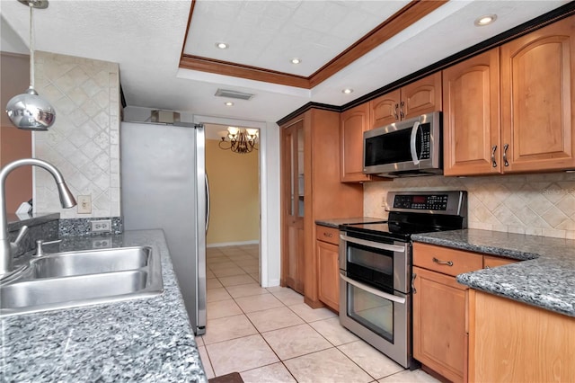 kitchen with sink, hanging light fixtures, ornamental molding, a tray ceiling, and stainless steel appliances