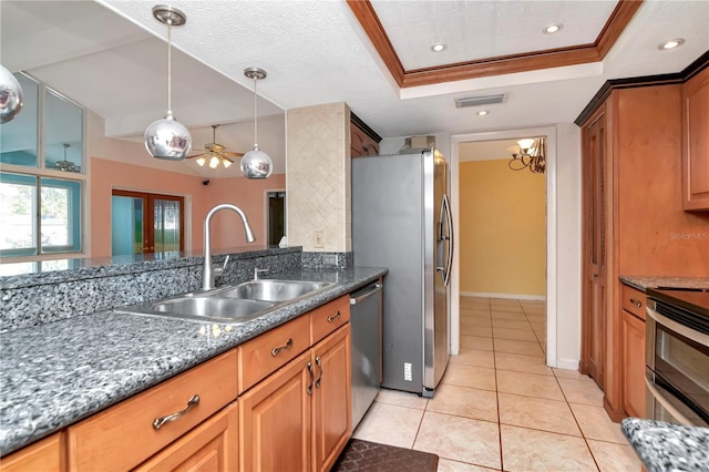 kitchen with sink, appliances with stainless steel finishes, ornamental molding, light tile patterned flooring, and a raised ceiling