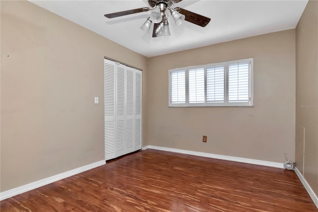 unfurnished bedroom featuring ceiling fan, dark hardwood / wood-style floors, and a closet