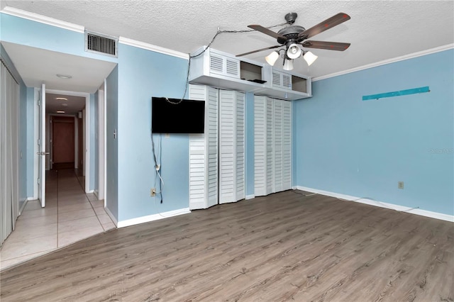 interior space featuring hardwood / wood-style floors, crown molding, a textured ceiling, and ceiling fan