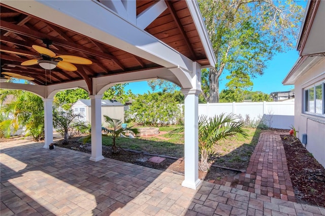 view of patio with ceiling fan and a storage shed