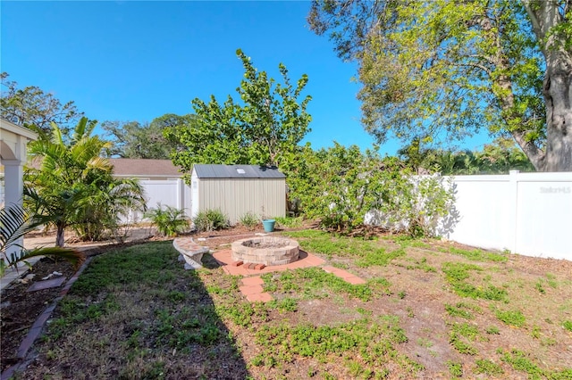 view of yard featuring a fire pit and a storage unit