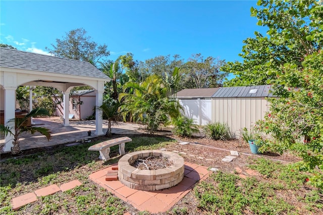 view of yard with a storage unit, a patio area, and an outdoor fire pit