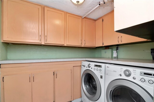 washroom with cabinets, separate washer and dryer, and a textured ceiling