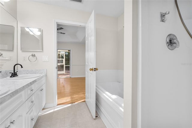 bathroom with tile patterned floors, vanity, and a bathing tub