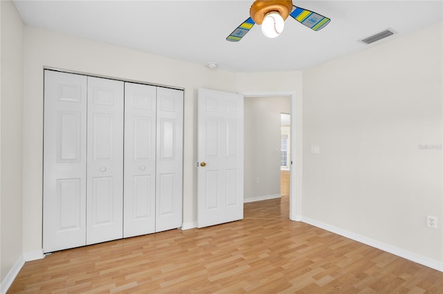 unfurnished bedroom featuring ceiling fan, light hardwood / wood-style floors, and a closet