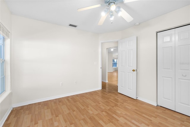 unfurnished bedroom with light hardwood / wood-style floors, a closet, and ceiling fan