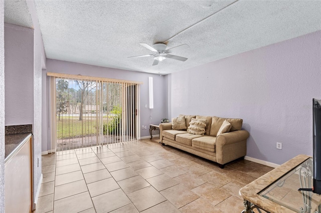 living room featuring ceiling fan and a textured ceiling