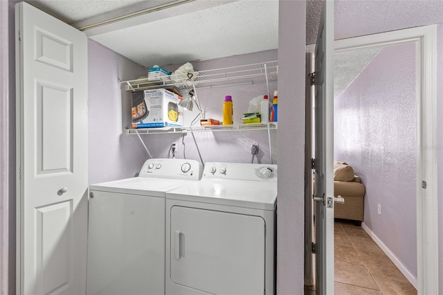 washroom with light tile patterned floors and washing machine and dryer