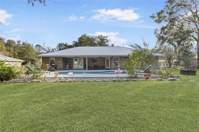 rear view of property with a lawn and a patio