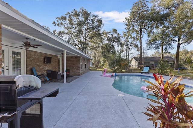 view of swimming pool featuring ceiling fan, grilling area, and a patio