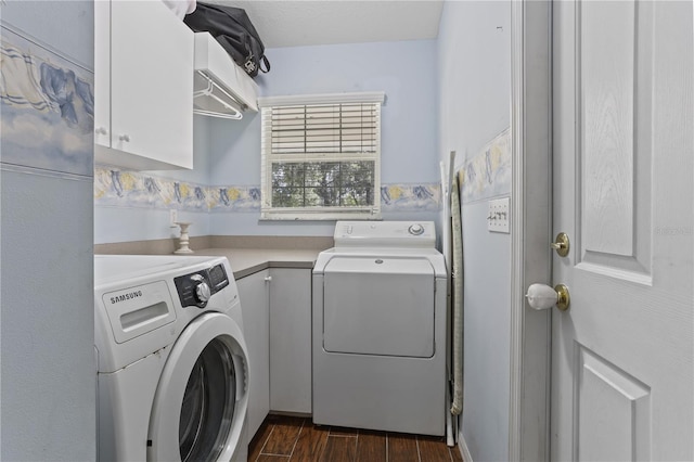 clothes washing area featuring separate washer and dryer and cabinets