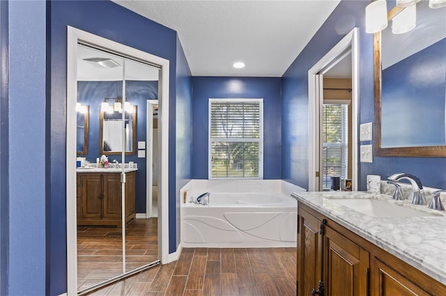 bathroom featuring vanity and a bath