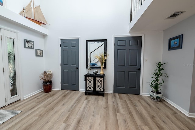 entrance foyer with light hardwood / wood-style floors and a high ceiling