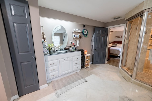 bathroom featuring ceiling fan, vanity, tile patterned flooring, and a shower with door