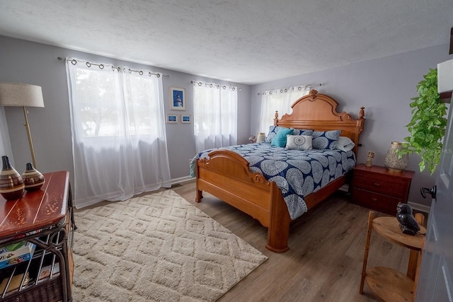 bedroom with hardwood / wood-style floors and a textured ceiling