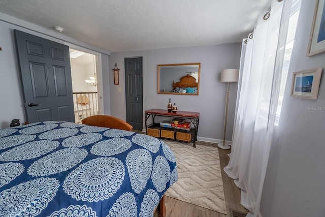 bedroom with a textured ceiling and light hardwood / wood-style floors