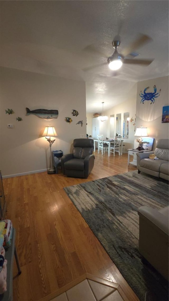 living room featuring hardwood / wood-style flooring, lofted ceiling, and ceiling fan