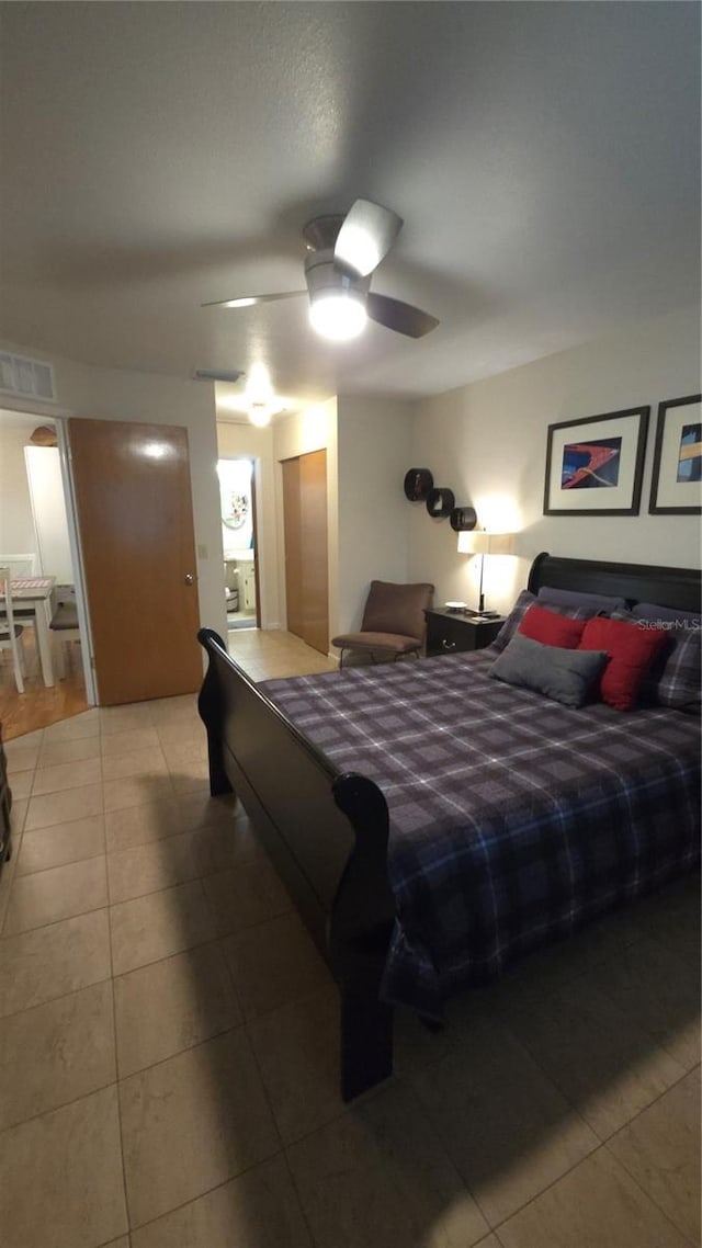 tiled bedroom featuring ceiling fan