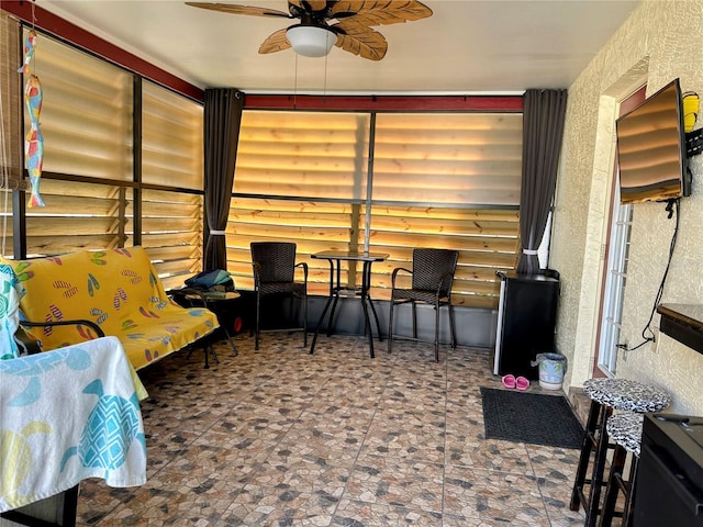 sunroom featuring ceiling fan