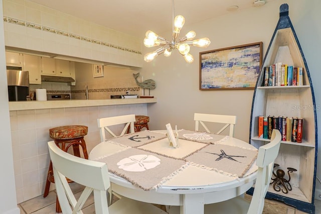 tiled dining area featuring sink and a chandelier