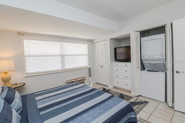 tiled bedroom with stacked washer / drying machine