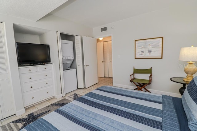 bedroom featuring a textured ceiling, light tile patterned floors, and a closet