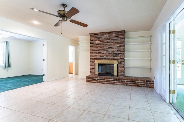 unfurnished living room with plenty of natural light, a fireplace, a textured ceiling, and light tile patterned floors