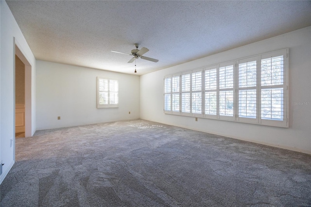 carpeted spare room featuring ceiling fan and a textured ceiling