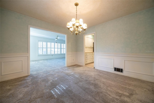 unfurnished dining area featuring a notable chandelier, light colored carpet, and a textured ceiling