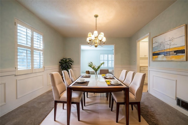 carpeted dining room with a chandelier