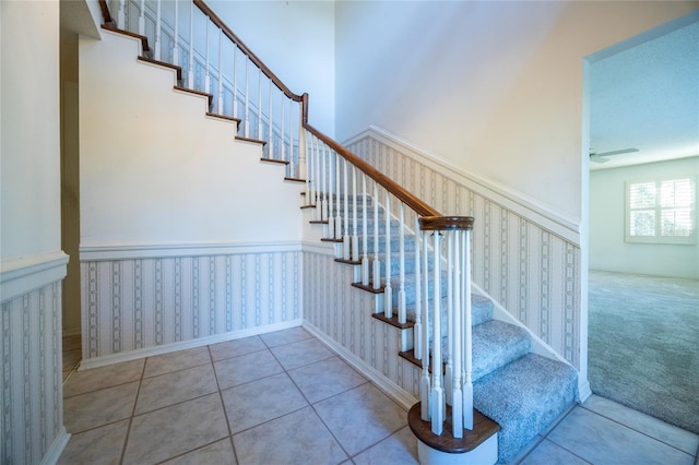 stairs featuring ceiling fan and tile patterned floors