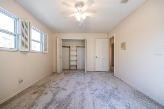 unfurnished bedroom featuring ceiling fan, light carpet, and a closet