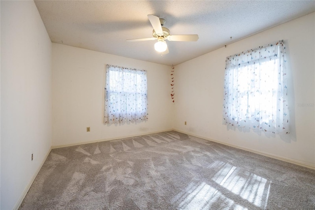 carpeted empty room with ceiling fan and a textured ceiling