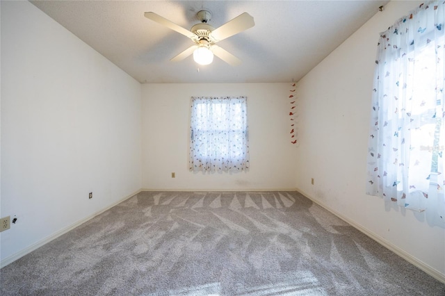 spare room with ceiling fan and carpet