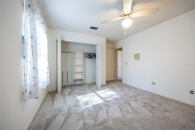 unfurnished bedroom with ceiling fan, light colored carpet, and a closet