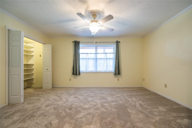 unfurnished bedroom with crown molding, ceiling fan, a spacious closet, and a closet