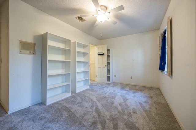 unfurnished bedroom with light carpet, a textured ceiling, and ceiling fan