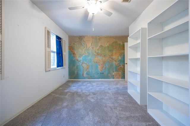 carpeted empty room with ceiling fan and a textured ceiling