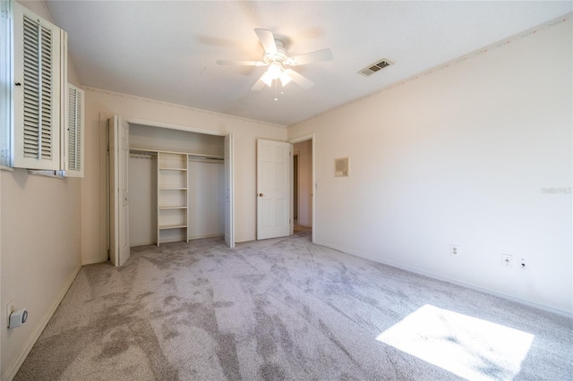 unfurnished bedroom with light colored carpet, ceiling fan, and a closet