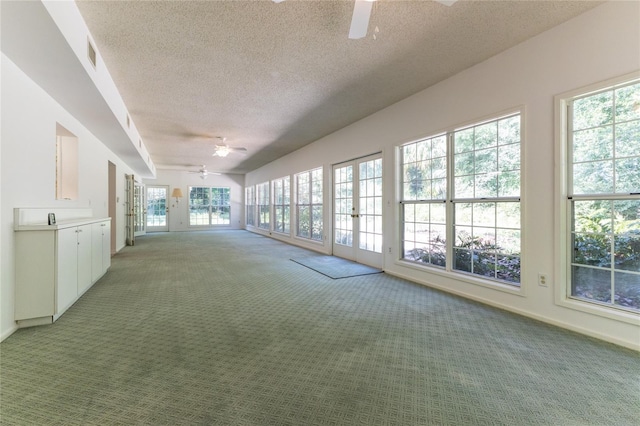 unfurnished sunroom featuring ceiling fan