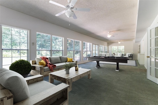 recreation room with ceiling fan, carpet, and a textured ceiling