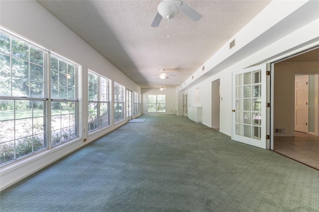 unfurnished sunroom featuring ceiling fan