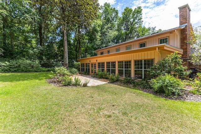 rear view of property with a patio and a lawn