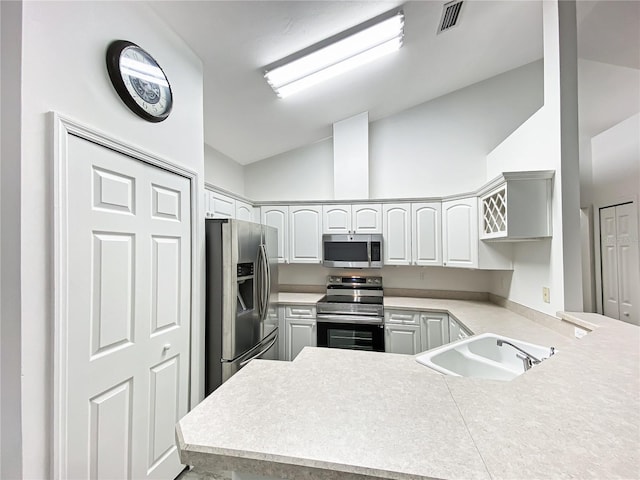 kitchen with appliances with stainless steel finishes, white cabinetry, sink, kitchen peninsula, and high vaulted ceiling