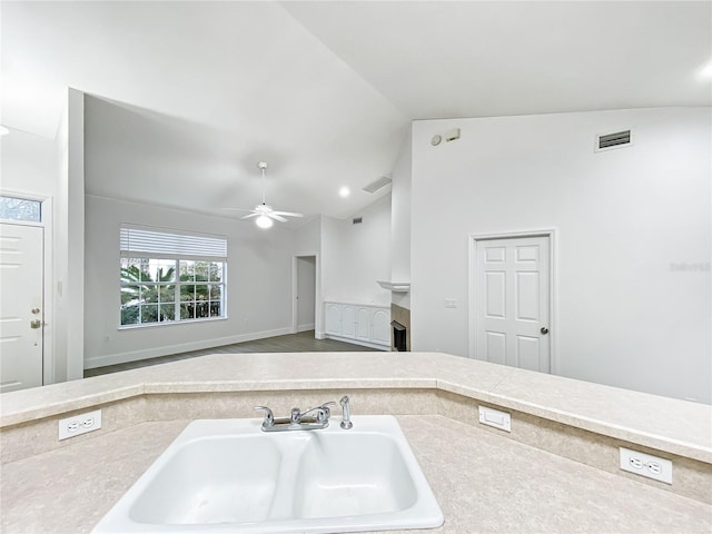 kitchen featuring ceiling fan, sink, and vaulted ceiling