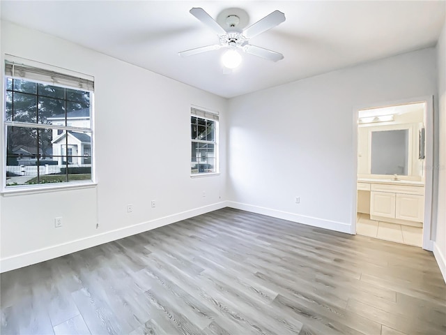 interior space with ceiling fan, sink, hardwood / wood-style floors, and ensuite bathroom