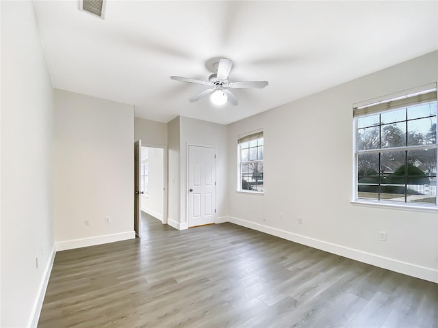 spare room with ceiling fan and dark hardwood / wood-style flooring